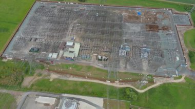 Dev elektrik santrali, elektrik santrali elektrik üretimi, elektrik direkleri ve rüzgar türbinli alt istasyonların havadan görüntüsü 