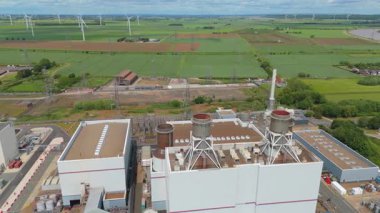 Dev elektrik santrali, elektrik santrali elektrik üretimi, elektrik direkleri ve rüzgar türbinli alt istasyonların havadan görüntüsü 