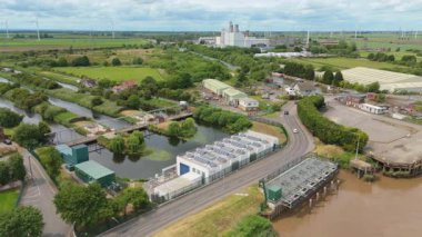 Dev elektrik santrali, elektrik santrali elektrik üretimi, elektrik direkleri ve rüzgar türbinli alt istasyonların havadan görüntüsü 