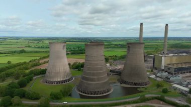Büyük enerji santralinin havadan görünüşü, soğutma kuleleri ve kırsal yeşil arazideki baca yığınları. Güneşli yaz günü İngiltere