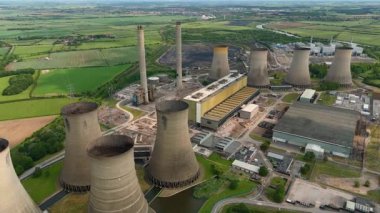 Büyük enerji santralinin havadan görünüşü, soğutma kuleleri ve kırsal yeşil arazideki baca yığınları. Güneşli yaz günü İngiltere