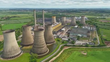Büyük enerji santralinin havadan görünüşü, soğutma kuleleri ve kırsal yeşil arazideki baca yığınları. Güneşli yaz günü İngiltere