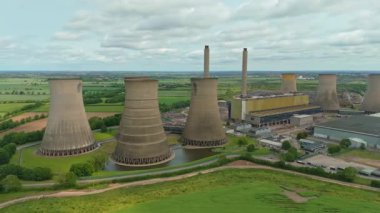 Büyük enerji santralinin havadan görünüşü, soğutma kuleleri ve kırsal yeşil arazideki baca yığınları. Güneşli yaz günü İngiltere