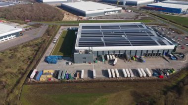 Büyük lojistik depoları ve dağıtım merkezleri, ağır yük kamyonları ve yükleme ambarları için hava aracı perspektifi, İngiltere