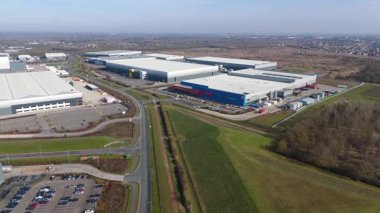 Büyük lojistik depoları ve dağıtım merkezleri, ağır yük kamyonları ve yükleme ambarları için hava aracı perspektifi, İngiltere