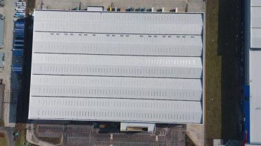 Büyük lojistik depoları ve dağıtım merkezleri, ağır yük kamyonları ve yükleme ambarları için hava aracı perspektifi, İngiltere