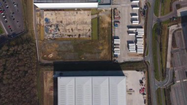 Büyük lojistik depoları ve dağıtım merkezleri, ağır yük kamyonları ve yükleme ambarları için hava aracı perspektifi, İngiltere