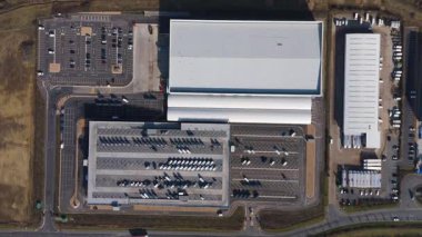 Büyük lojistik depoları ve dağıtım merkezleri, ağır yük kamyonları ve yükleme ambarları için hava aracı perspektifi, İngiltere