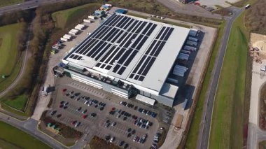 Büyük lojistik depoları ve dağıtım merkezleri, ağır yük kamyonları ve yükleme ambarları için hava aracı perspektifi, İngiltere