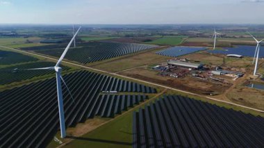 Büyük rüzgar türbini ve güneş paneli dizisinin hava aracı görüntüsü, yenilenebilir enerji santrali güneşli bahar sabahı Birleşik Krallık. Elektrik gücü..