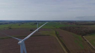 Büyük rüzgar türbini ve güneş paneli dizisinin hava aracı görüntüsü, yenilenebilir enerji santrali güneşli bahar sabahı Birleşik Krallık. Elektrik gücü..