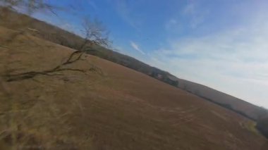 FPV insansız hava aracı gün batımında İngiltere 'nin yeşil arazilerinden geçer, çiftlik hayvanlarının, çitlerin ve çayırların yanından geçer, yukarıdan kırsal manzaranın güzelliğini yakalar.