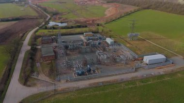 İngiltere 'deki elektrik alt istasyonu ve elektrik hatlarının hava aracı görüntüsü, trafolar ve şalterler.