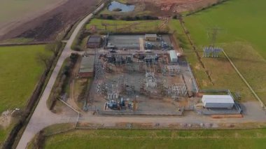 İngiltere 'deki elektrik alt istasyonu ve elektrik hatlarının hava aracı görüntüsü, trafolar ve şalterler.