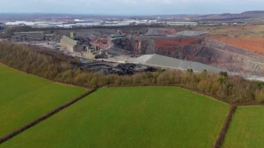 Dev taş ocağı, açık çukur madeni, çakıl ve nadir bulunan toprak mineral çıkarma, taşıma bantları ve bitki makinelerinden oluşan hava aracı perspektifi.