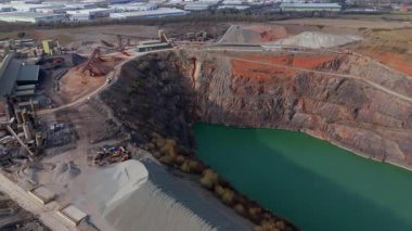 Dev taş ocağı, açık çukur madeni, çakıl ve nadir bulunan toprak mineral çıkarma, taşıma bantları ve bitki makinelerinden oluşan hava aracı perspektifi.