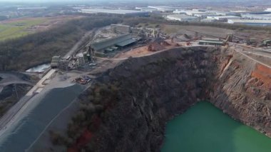 Dev taş ocağı, açık çukur madeni, çakıl ve nadir bulunan toprak mineral çıkarma, taşıma bantları ve bitki makinelerinden oluşan hava aracı perspektifi.