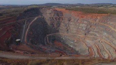 Dev taş ocağı, açık çukur madeni, çakıl ve nadir bulunan toprak mineral çıkarma, taşıma bantları ve bitki makinelerinden oluşan hava aracı perspektifi.