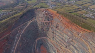 Dev taş ocağı, açık çukur madeni, çakıl ve nadir bulunan toprak mineral çıkarma, taşıma bantları ve bitki makinelerinden oluşan hava aracı perspektifi.