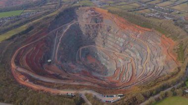 Dev taş ocağı, açık çukur madeni, çakıl ve nadir bulunan toprak mineral çıkarma, taşıma bantları ve bitki makinelerinden oluşan hava aracı perspektifi.