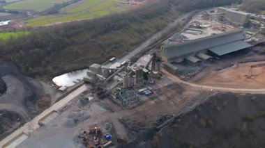 Dev taş ocağı, açık çukur madeni, çakıl ve nadir bulunan toprak mineral çıkarma, taşıma bantları ve bitki makinelerinden oluşan hava aracı perspektifi.