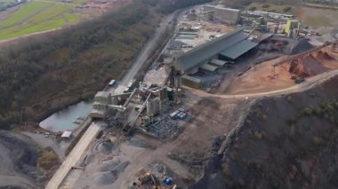 Dev taş ocağı, açık çukur madeni, çakıl ve nadir bulunan toprak mineral çıkarma, taşıma bantları ve bitki makinelerinden oluşan hava aracı perspektifi.