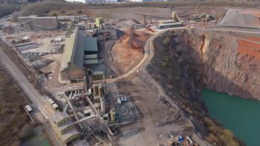 Dev taş ocağı, açık çukur madeni, çakıl ve nadir bulunan toprak mineral çıkarma, taşıma bantları ve bitki makinelerinden oluşan hava aracı perspektifi.