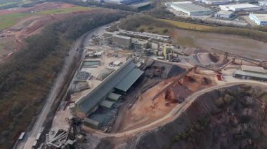 Dev taş ocağı, açık çukur madeni, çakıl ve nadir bulunan toprak mineral çıkarma, taşıma bantları ve bitki makinelerinden oluşan hava aracı perspektifi.
