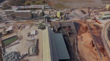 Dev taş ocağı, açık çukur madeni, çakıl ve nadir bulunan toprak mineral çıkarma, taşıma bantları ve bitki makinelerinden oluşan hava aracı perspektifi.