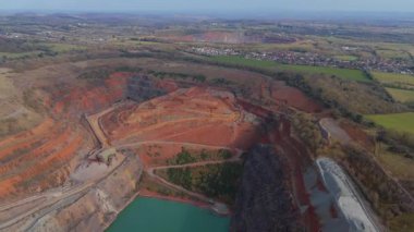 Dev taş ocağı, açık çukur madeni, çakıl ve nadir bulunan toprak mineral çıkarma, taşıma bantları ve bitki makinelerinden oluşan hava aracı perspektifi.