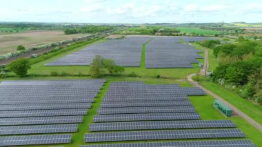 Güneş enerjisi santralinin hava aracı görüntüsü, yenilenebilir elektrik üreten fotovoltaik paneller, kırsal alanda yeşil enerji altyapısı, Avrupa Birleşik Devletleri.