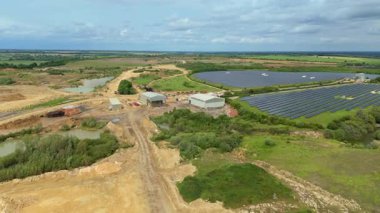 Güneş enerjisi santralinin hava aracı görüntüsü, yenilenebilir elektrik üreten fotovoltaik paneller, kırsal alanda yeşil enerji altyapısı, Avrupa Birleşik Devletleri.