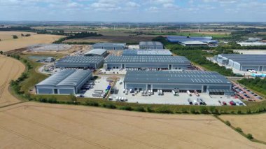 Biggleswade İngiltere 'deki kamyon kargo ithalat ve ihracatıyla birlikte dağıtım depolarının ve veri merkezi lojistik merkezinin insansız hava aracı görüntüsü.