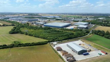 Biggleswade İngiltere 'deki kamyon kargo ithalat ve ihracatıyla birlikte dağıtım depolarının ve veri merkezi lojistik merkezinin insansız hava aracı görüntüsü.