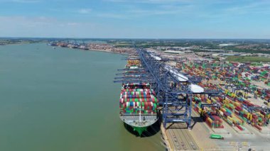 Büyük endüstriyel nakliye limanının hava aracı görüntüsü, ithalat için gemilere yüklenen kargo konteynırı yükü, İngiltere Felixstowe 'deki gantry vinçleri.
