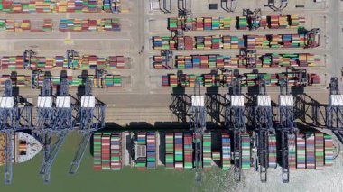 Büyük endüstriyel nakliye limanının hava aracı görüntüsü, ithalat için gemilere yüklenen kargo konteynırı yükü, İngiltere Felixstowe 'deki gantry vinçleri.
