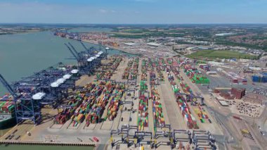 Büyük endüstriyel nakliye limanının hava aracı görüntüsü, ithalat için gemilere yüklenen kargo konteynırı yükü, İngiltere Felixstowe 'deki gantry vinçleri.