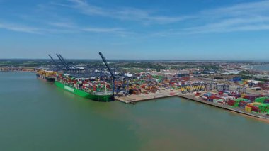 Büyük endüstriyel nakliye limanının hava aracı görüntüsü, ithalat için gemilere yüklenen kargo konteynırı yükü, İngiltere Felixstowe 'deki gantry vinçleri.