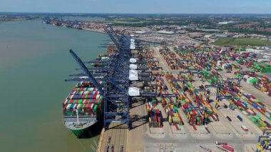 Büyük endüstriyel nakliye limanının hava aracı görüntüsü, ithalat için gemilere yüklenen kargo konteynırı yükü, İngiltere Felixstowe 'deki gantry vinçleri.