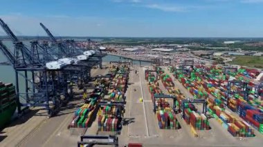 Büyük endüstriyel nakliye limanının hava aracı görüntüsü, ithalat için gemilere yüklenen kargo konteynırı yükü, İngiltere Felixstowe 'deki gantry vinçleri.
