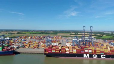 Büyük endüstriyel nakliye limanının hava aracı görüntüsü, ithalat için gemilere yüklenen kargo konteynırı yükü, İngiltere Felixstowe 'deki gantry vinçleri.