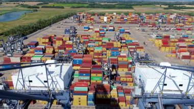 Büyük endüstriyel nakliye limanının hava aracı görüntüsü, ithalat için gemilere yüklenen kargo konteynırı yükü, İngiltere Felixstowe 'deki gantry vinçleri.
