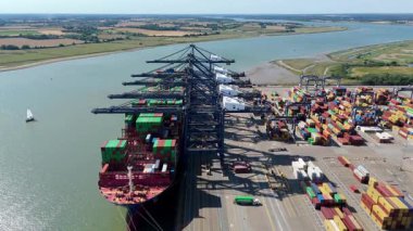 Büyük endüstriyel nakliye limanının hava aracı görüntüsü, ithalat için gemilere yüklenen kargo konteynırı yükü, İngiltere Felixstowe 'deki gantry vinçleri.