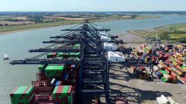 Büyük endüstriyel nakliye limanının hava aracı görüntüsü, ithalat için gemilere yüklenen kargo konteynırı yükü, İngiltere Felixstowe 'deki gantry vinçleri.