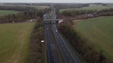 Trafik ve arabalarla dolu işlek otoyolun havadan görüntüsü, İngiltere 'de ulaşım ve seyahat için otoyollar.