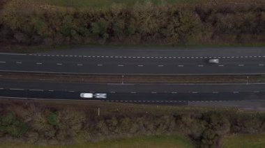 Trafik ve arabalarla dolu işlek otoyolun havadan görüntüsü, İngiltere 'de ulaşım ve seyahat için otoyollar.