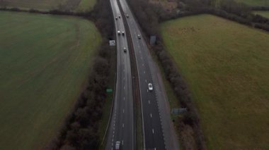 Trafik ve arabalarla dolu işlek otoyolun havadan görüntüsü, İngiltere 'de ulaşım ve seyahat için otoyollar.