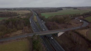 Trafik ve arabalarla dolu işlek otoyolun havadan görüntüsü, İngiltere 'de ulaşım ve seyahat için otoyollar.