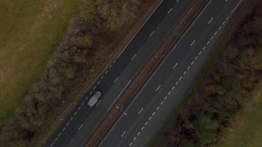 Trafik ve arabalarla dolu işlek otoyolun havadan görüntüsü, İngiltere 'de ulaşım ve seyahat için otoyollar.