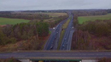 Trafik ve arabalarla dolu işlek otoyolun havadan görüntüsü, İngiltere 'de ulaşım ve seyahat için otoyollar.